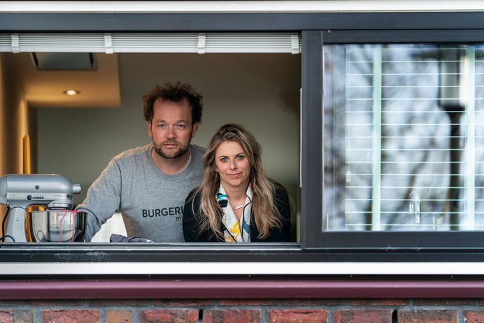 Edwin Klaasen en zijn vriendin Vivian Blinksma kijkend uit het raam van hun huis, net nadat bekend was geworden dat hij corona had.