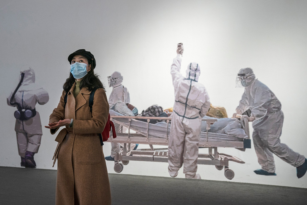 Een vrouw draagt een gezichtsmasker terwijl ze een tentoonstelling in Wuhan bezoekt over de strijd van de stad tegen het coronavirus. Beeld Getty Images