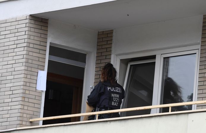 Een politieagent tijdens de huiszoeking in het appartement.