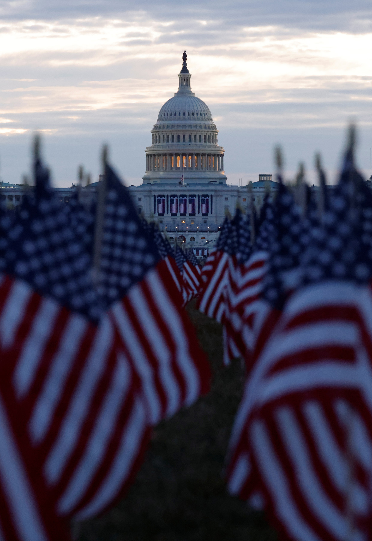 Duizenden Amerikaanse vlaggen zijn neergezet voor het Capitool in Washington DC als eerbetoon aan de Amerikanen die zijn overleden aan het coronavirus.  Beeld REUTERS