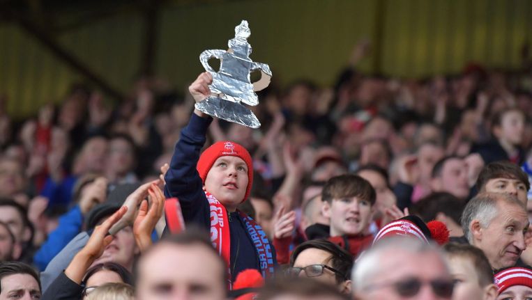 Een jonge fan van Lincoln City houdt een zelfgemaakt exemplaar van de FA Cup boven zijn hoofd bij de gewonnen wedstrijd tegen Burnley. Beeld afp