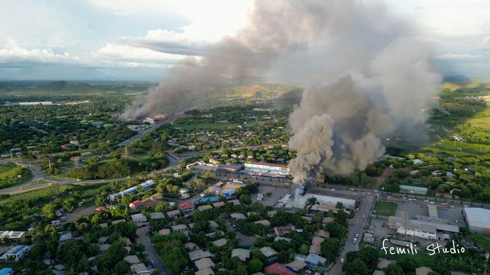 Rookpluimen van brandende gebouwen boven Port Moresby.