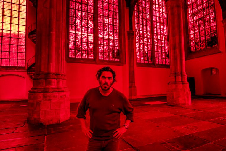 De Italiaanse kunstenaar Giorgio Andreotta Calò beplakte de ramen van de Oude Kerk in Amsterdam met rode folie en plexiglas: 'Zo wil ik de geschiedenis van deze kerk zichtbaar maken voor de bezoeker'. Beeld Patrick Post