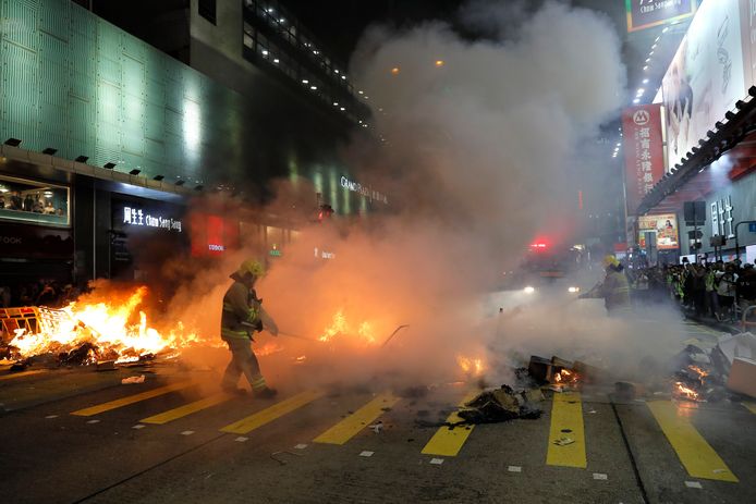 De brandweer blust een brand veroorzaakt door demonstranten in Mong Kok.
