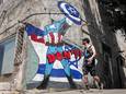 Een man loopt in Tel Aviv langs een muurschildering gemaakt door de graffiti-kunstgroep ‘Grafitiyul’, waarop de Amerikaanse president Joe Biden is afgebeeld als de Marvel-stripfiguur Captain America die Israël met een schild beschermt tegen buitenlandse aanvallen.