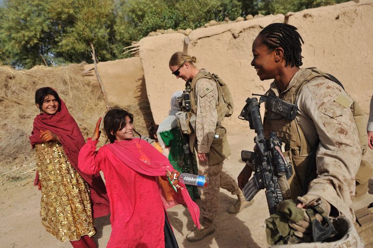 Amerikaanse mariniers nemen even hun helm af om twee meisjes te tonen dat ze vrouwen zijn. Beeld © Lynsey Addario / 2021 The Atlantic Monthly Group, Inc.   All rights reserved. Distributed by Tribune Content Agency