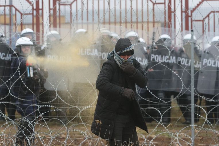 Poolse veiligheidstroepen zetten waterkanonnen en traangas in tegen migranten in het grensgebied met Wit-Rusland. Beeld AFP