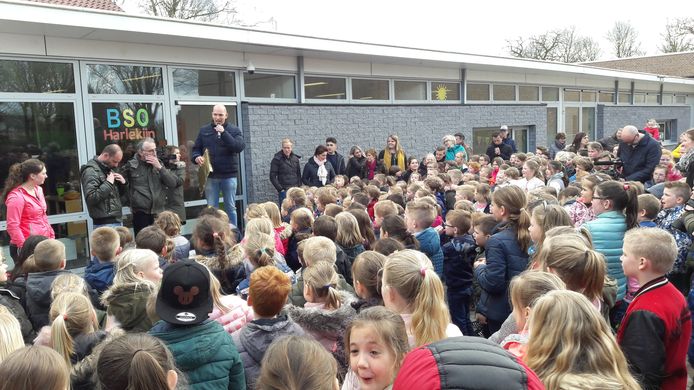 Leerkracht Martijn Schrauwen vertelt de kinderen van basisschool De Brakken dat de sponsoractie voor conciërge Meneer Jan van Heijst 7.000 euro heeft opgebracht. Jan en zijn zoon Maarten kunnen het niet geloven.