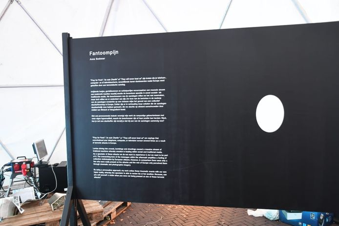 Passerende bezoekers zien de achterkant van het kunstwerk