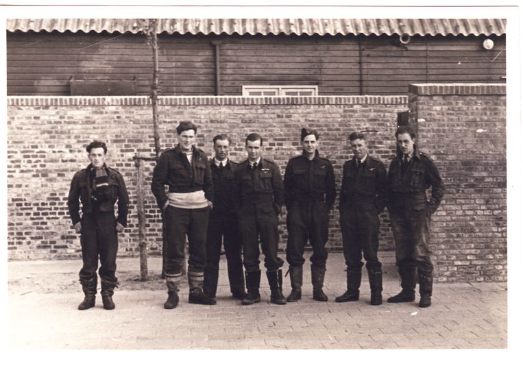 De gevangengenomen bemanning van de Short Stirling W7471 op Vliegbasis Leeuwarden. Van links naar rechts: Sergeant Jack Arnold, Sergeant S.J. (‘Mac’) MacNamara, Wireless Operator/Air Gunner Pilot Officer John Travis, piloot Warant Officer N.L. (‘Buck’) Tayler, tweede piloot Sergeant Frank Henigman, Observer Pilot Officer Ted Earngey en Sergeant Air Gunner Bill Goodman met de sporen van zijn kruippartij door het slik nog aan zijn broek. Boordschutter Flying Officer Harry Spry staat niet op de foto, omdat hij op dat moment in het ziekenhuis werd behandeld voor zijn verstuikte enkel.  Beeld Collectie Gerard Groeneveld
