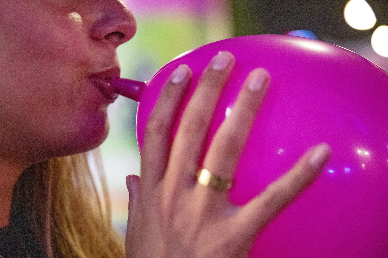 Een vrouw met een lachgasballon aan haar mond.