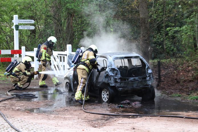 Brandweerlieden blussen het vuur in de Peugeot 108, maar die is niet meer te redden.