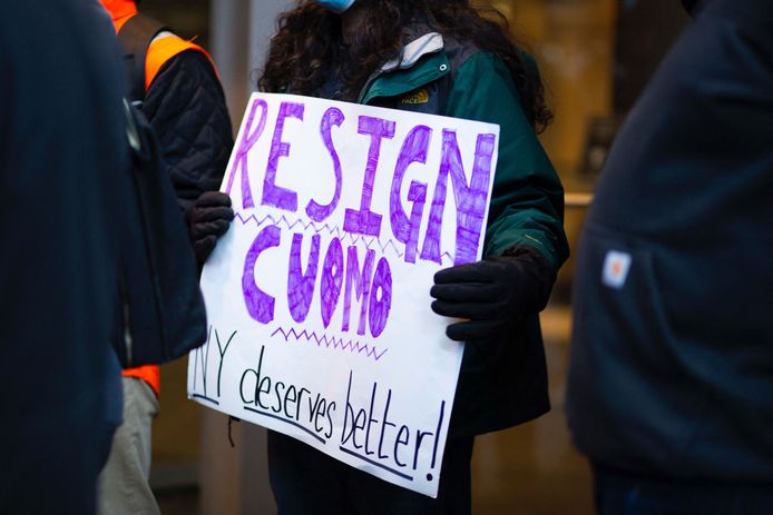 Een vrouw protesteert tegen het aanblijven van gouverneur Cuomo. 'New York verdient beter', staat er op het bord dat ze vasthoudt.