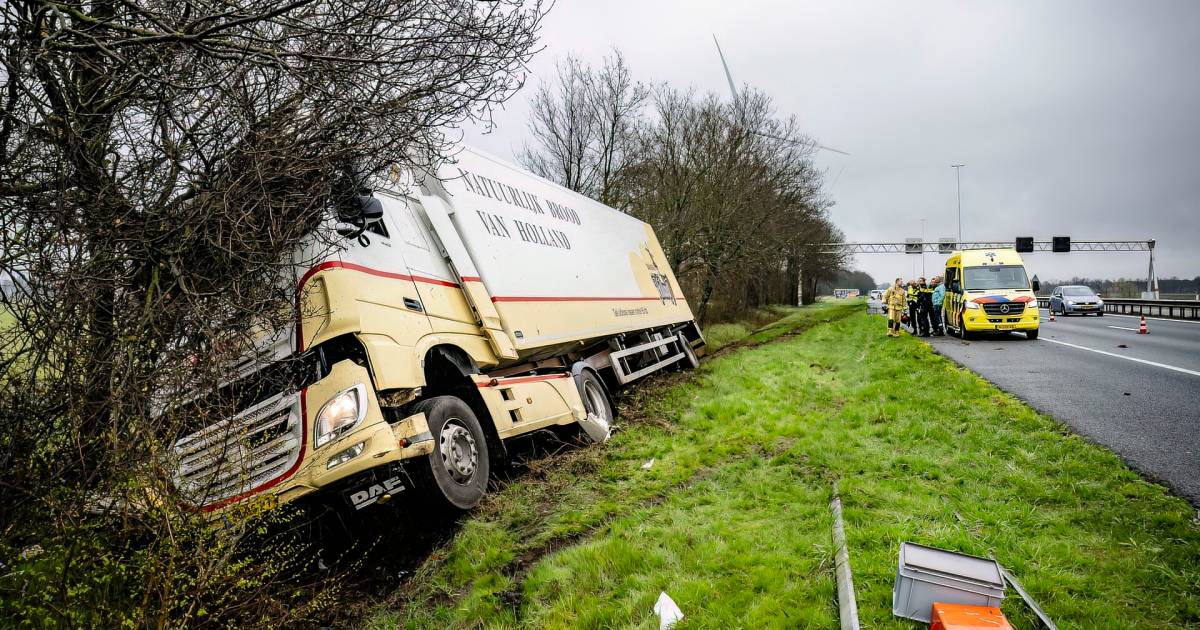 Vrachtwagen in greppel naast A58 bij Oirschot: cabine van chauffeur deukt volledig in door botsing met boom.