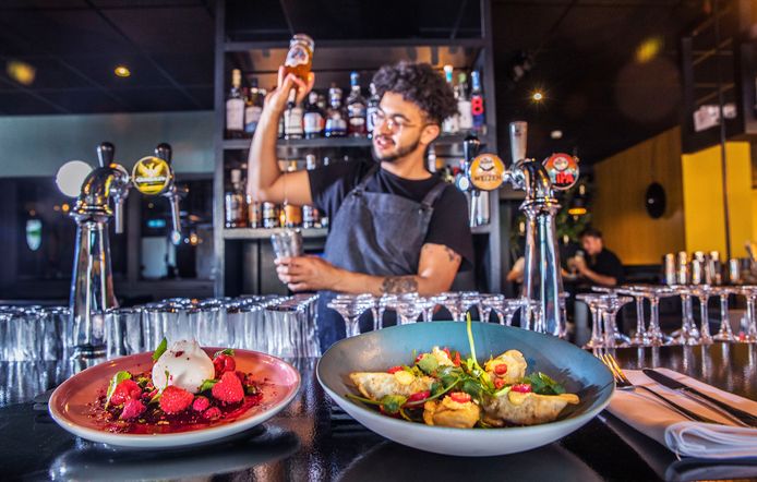 Gastro-coctailbar Annabel. Op de voorgrond links bietencarpaccio met framboos en rechts Gyoza. Op de achtergrond worden er cocktails gemaakt.