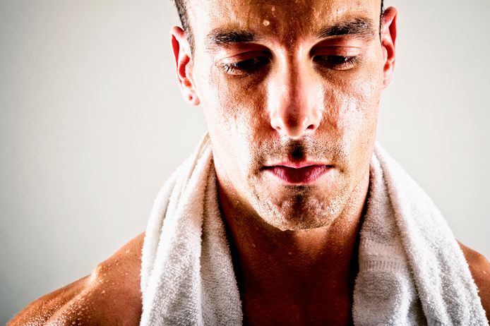 Sweaty Caucasian athlete wearing towel after exercise