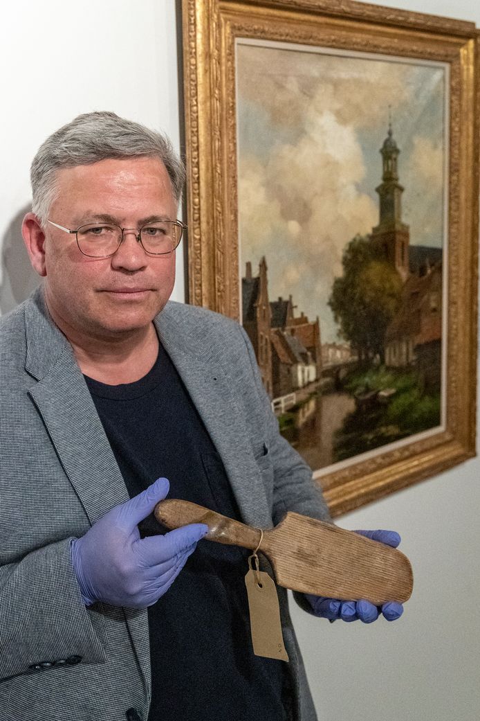 Hans van de Bunte, interim-directeur van Museum De Voorde in Zoetermeer, met een eeuwenoude boterspaan.