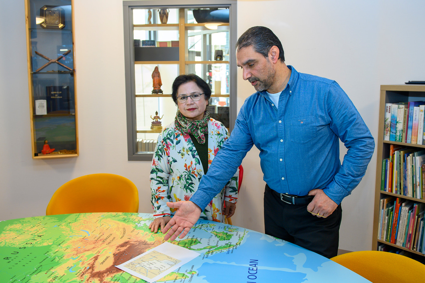 Parwin Roien (l) en Zaher Farahi laten op een kaart zien waar ze de naaiateliers willen opzetten.