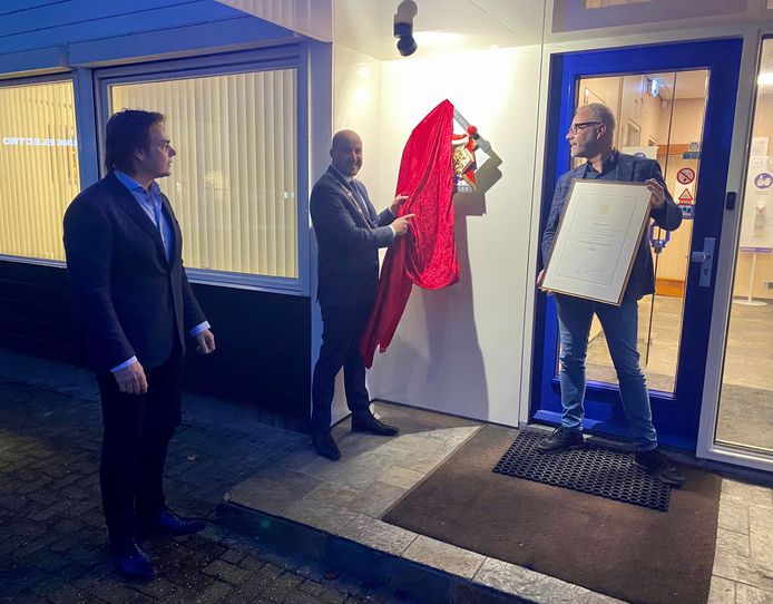 Burgemeester Ahmed Marcouch onthult bij Verhoeven Vastgoedverbeteraars het schild met het Koninklijk Wapen.