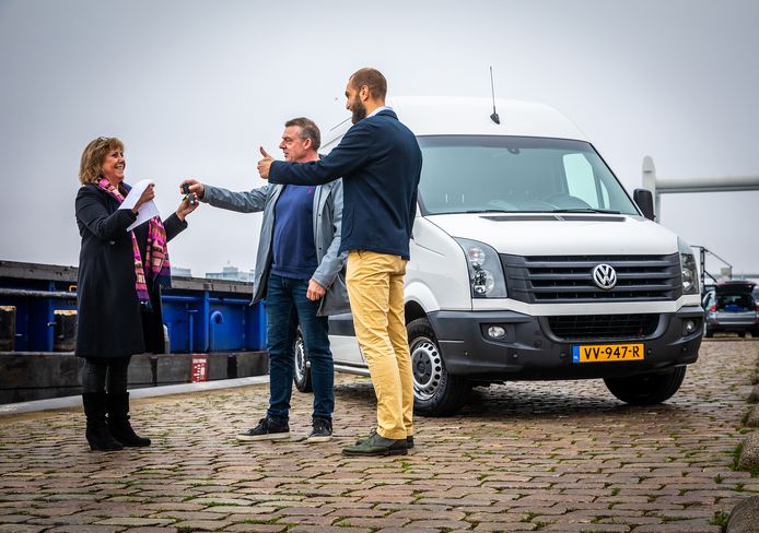 Suzan de Groot (links) ontvangt namens Koos Bakker (midden) en Jeroen Markusse (rechts) de sleutels van hun nieuwe busje.