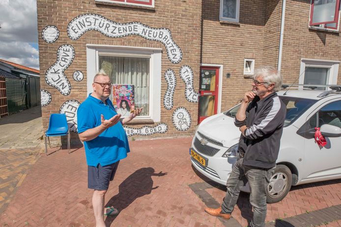 Marco Maas (l) en kunstenaar André Smits in gesprek bij de door Smits beschilderde woning van Maas.