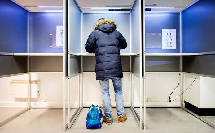Een man brengt zijn stem uit in een kieslokaal.