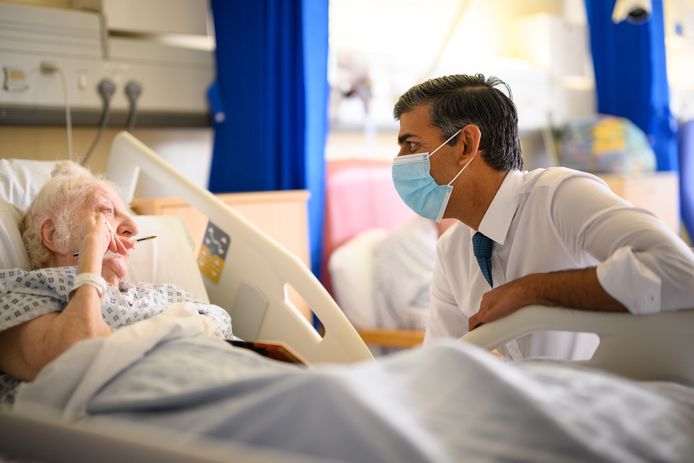 De Britse premier Sunak spreekt met een patiënt in een ziekenhuis in het zuiden van Londen. Archiefbeeld.