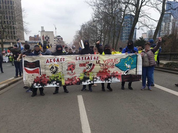 Manifestanten achter een spandoek dat drie antifascistische groepen uit Frankrijk identificeert