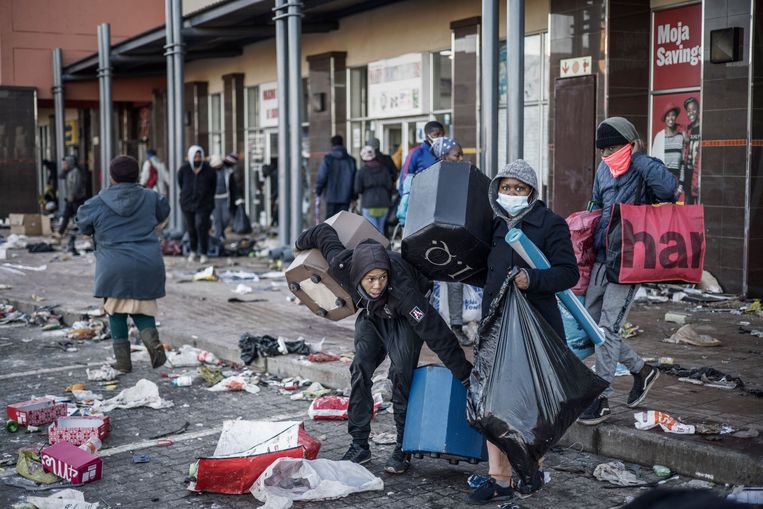 Plunderaars grijpen wat ze kunnen bij het winkelcentrum in Vosloorus tijdens rellen in Zuid-Afrika de afgelopen dagen.  Beeld AFP