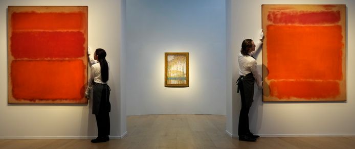 Werknemers van Christie's hangen de schilderen ‘Untitled (Shades of Red)‘ (links, iets goedkoper) en ‘No. 1’ (rechts) goed.