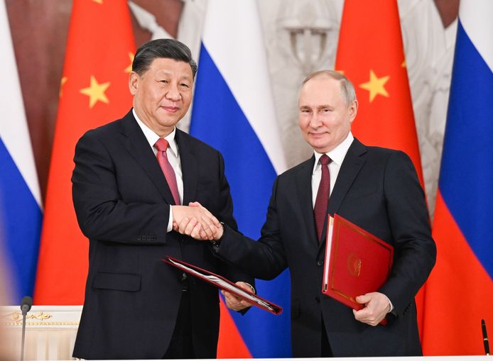 Xi Jinping en Vladimir Poetin schudden elkaars hand.