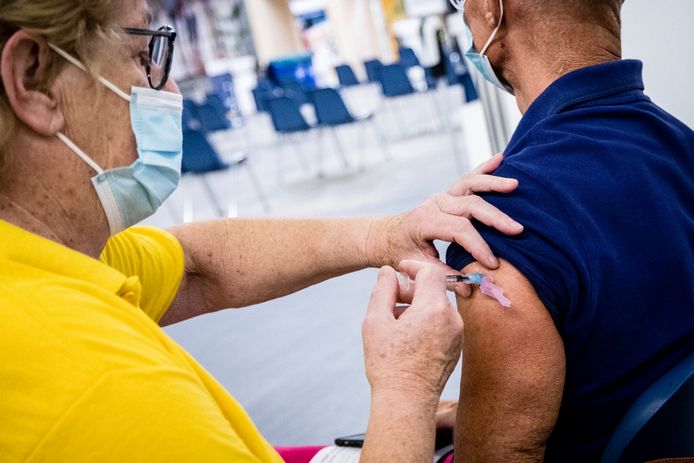 Een medewerker zet een boosterprik van Moderna bij de vaccinatielocatie van de GGD Brabant Zuidoost.