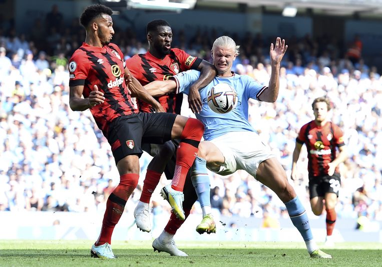 Manchester City-aanwinst Erling Haaland duwt twee spelers van Bournemouth opzij in de Premier League. Beeld ANP / EPA