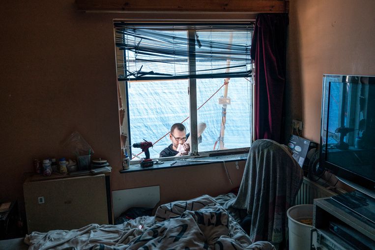 Lauwrence de Vries dicht de gaten in zijn huis. 'Het is één grote tochtbende.' Beeld Reyer Boxem