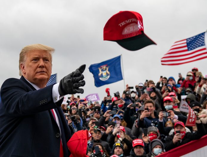President Donald Trump gooit een van zijn befaamde caps richting zijn aanhang tijdens de campagnebijeenkomst in Waterford Township, in de Amerikaanse staat Michigan.