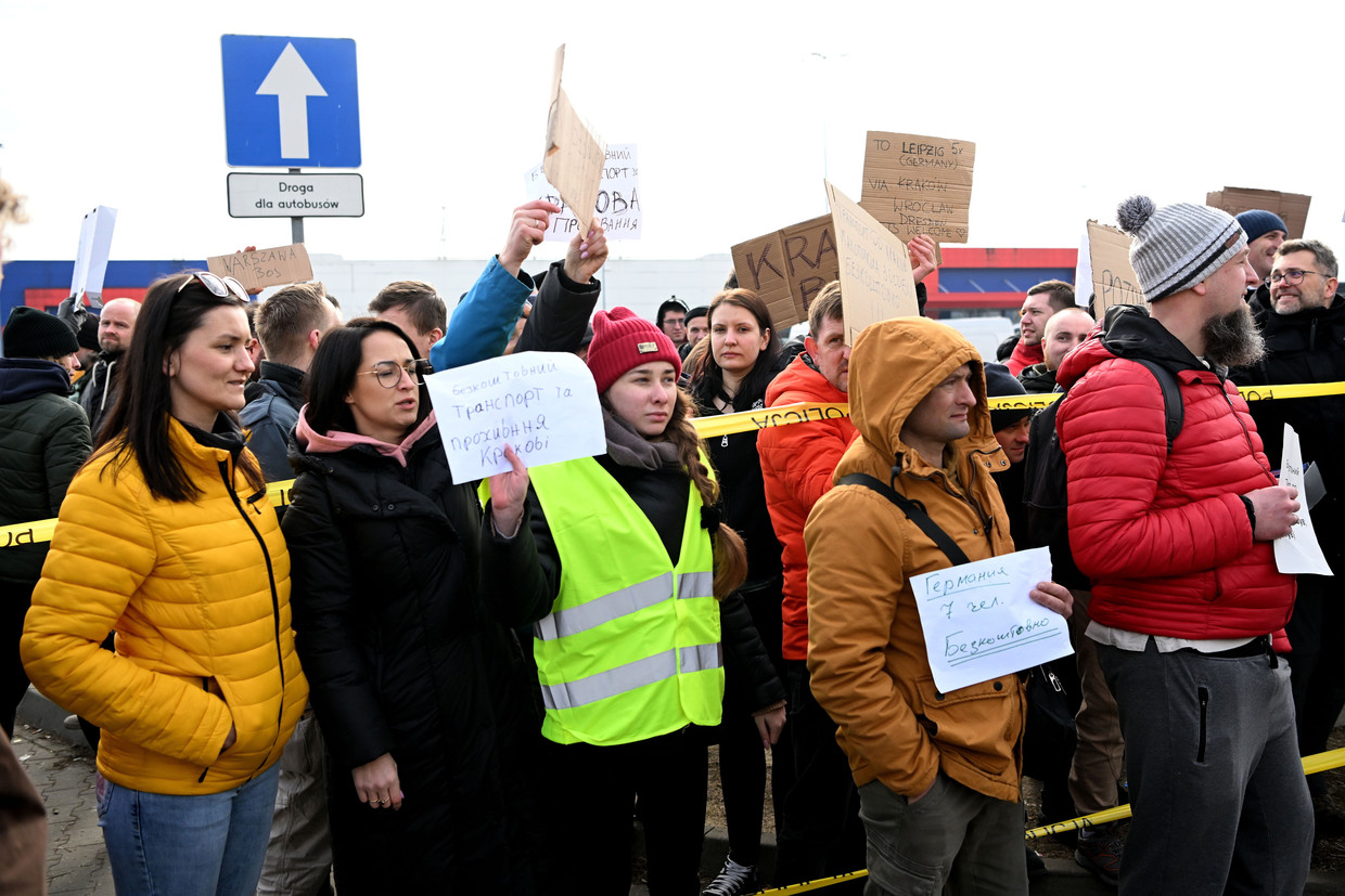 Poolse burgers bieden Oekraïense vluchtelingen een lift aan bij een hulppost aan de grens. Beeld EPA