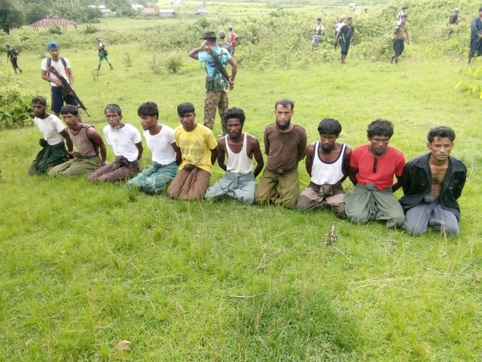 Tien Rohingya-mannen moeten met hun handen achter hun rug vastgebonden knielen voor Myanmarese veiligheidskrachten in het dorpje Inn Din in de staat Rakhine. Archiefbeeld uit 2017.