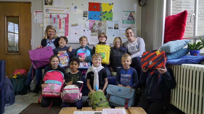 Directeur Marie Boullart (links) en leerkracht Michèle Persyn (rechts) tonen samen met de de leerlingen enkele van de goedgevulde schooltassen.

BuBaO Sint-Idesbald De Zilten verzamelen 50 boekentasjes met speelgoed en educatief materiaal voor kinderen getroffen door de oorlog in Oekraïne.