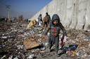 Een Afghaans kind zoekt op een vuilnisbelt naar plastic. Beeld uit 2019.