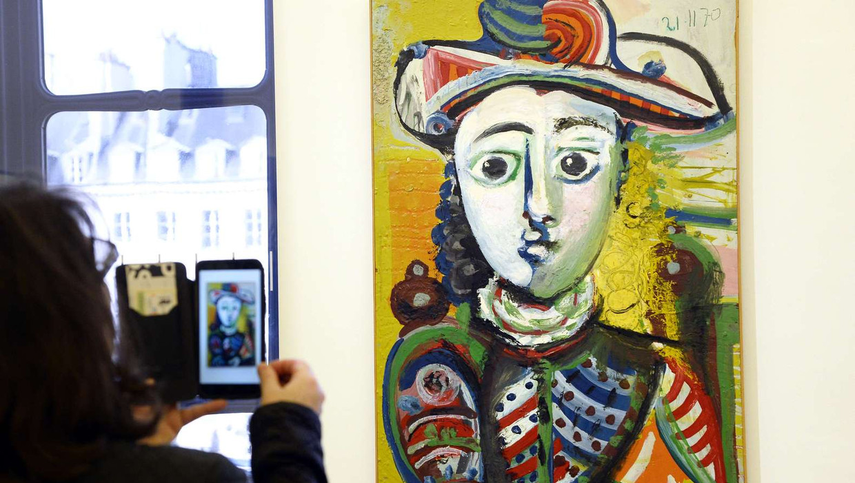 Een bezoeker neemt een foto van een echte Picasso tijdens de opening van een tentoonstelling in Parijs. De foto is van oktober. Beeld afp