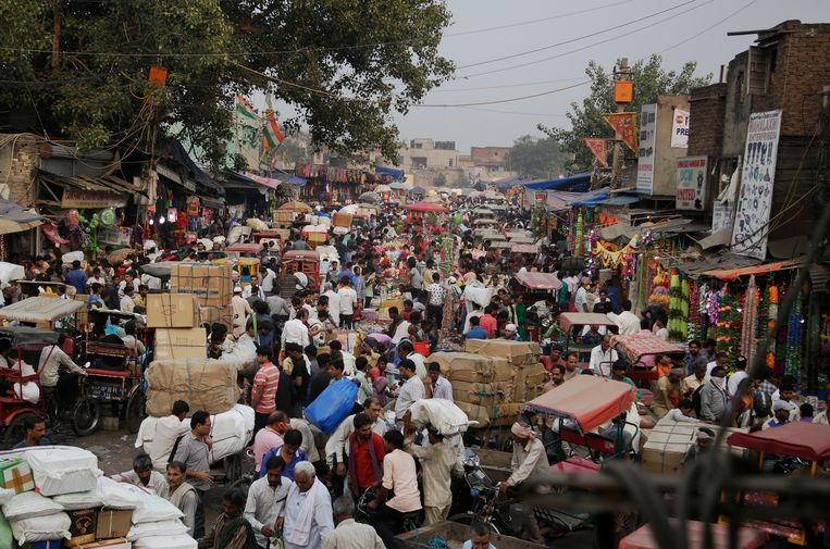 Een mensenmenigte op een markt in New Delhi. India is na China het land met de meeste inwoners.   Beeld AP