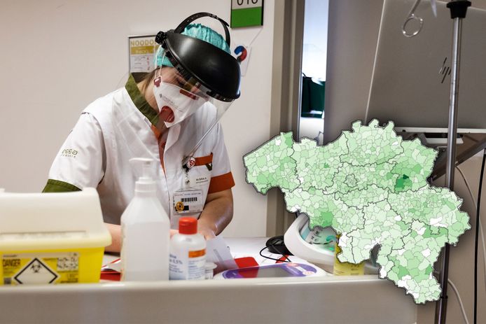 Medewerker in het Hasseltse Jessa Ziekenhuis. Op de kaart worden de huidige coronabesmettingen weergegeven. Donkere tinten groen geven meer besmettingen aan.