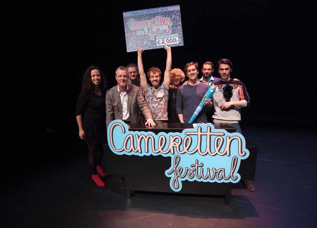 ► Winnaar Pieter Verelst pronkt met zijn cheque te midden van de festivaljury en de andere finalisten. Beeld Jaap Reedijk