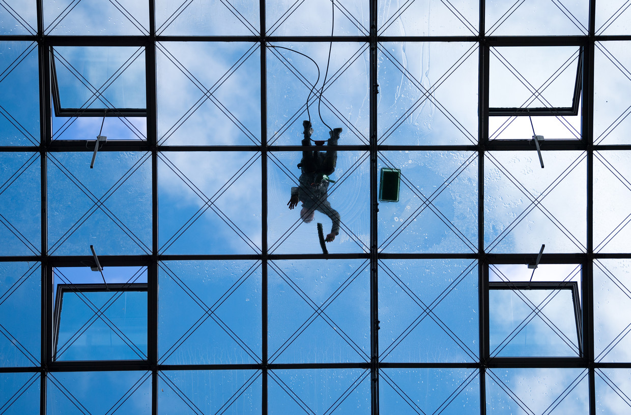Een glazenwasser is aan het werk op het dak van het World Trade Center in Dresden. Beeld Hollandse Hoogte /