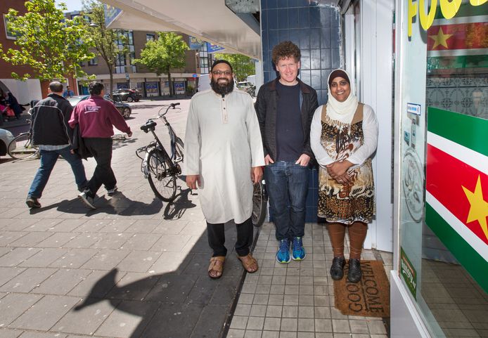 In het midden: Itai Cohn, bewoner van de Schilderswijk en organisator van tours door de wijk. Hij doet dan ook verschillende ondernemers aan zoals hier de famillie Ahmed van de winkel Food 786.