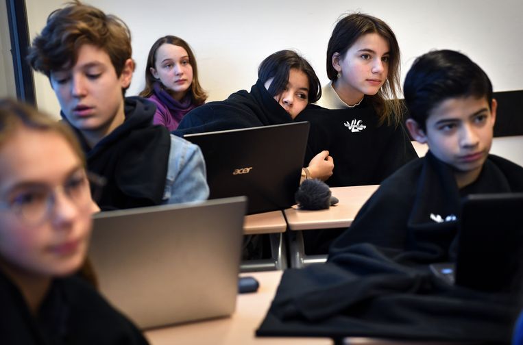 Kinderen zitten in de klas met fleecedekentjes om zich heen geslagen. Beeld Marcel van den Bergh