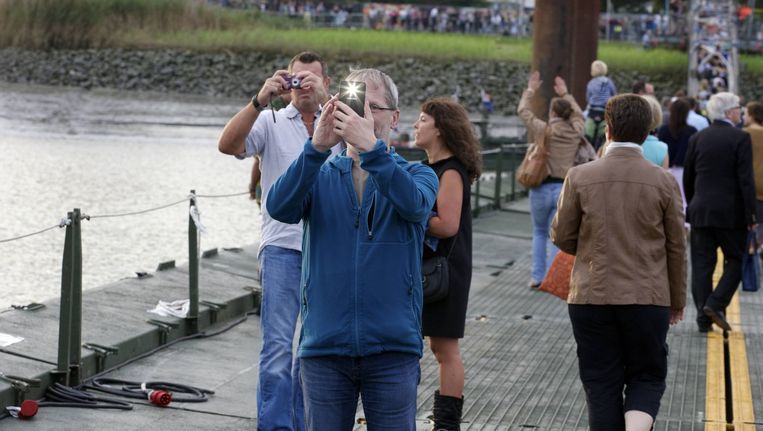 Bezoekers maken foto's op de pontonbrug over de Schelde. Beeld BELGA