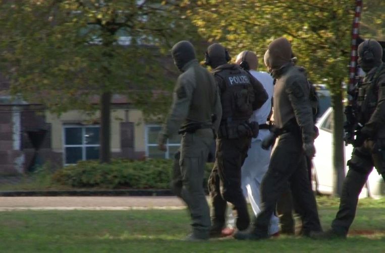 De 27-jarige dader wordt onder politiebegeleiding weggebracht naar het gerechtsgebouw van Karlsruhe. Beeld AFP
