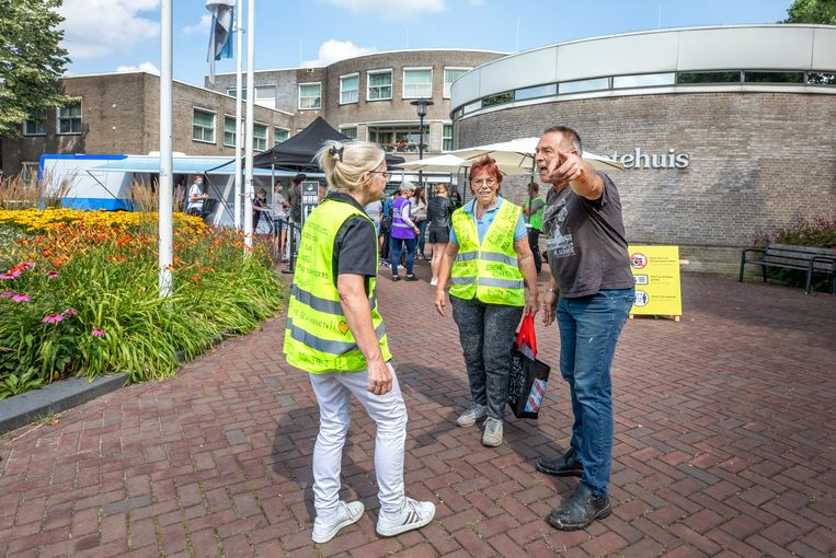 Confrontatie tussen een man die  pro-vacccinatie is (midden) en tegenstanders van vaccinatie in de gele hesjes bij prikbus in Lekkerkerk.  Beeld Raymond Rutting / de Volkskrant