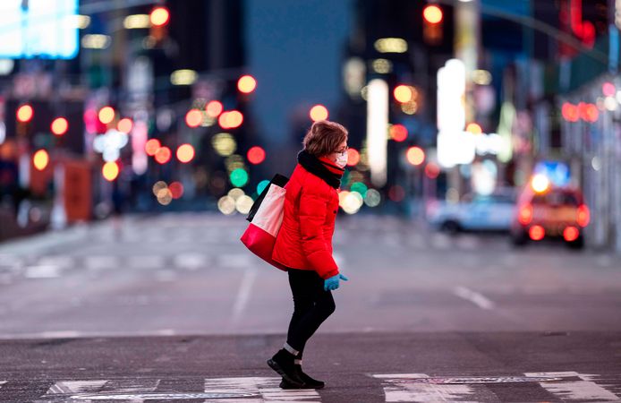 Op vrouw wandelt op een quasi verlaten Times Square in New York.